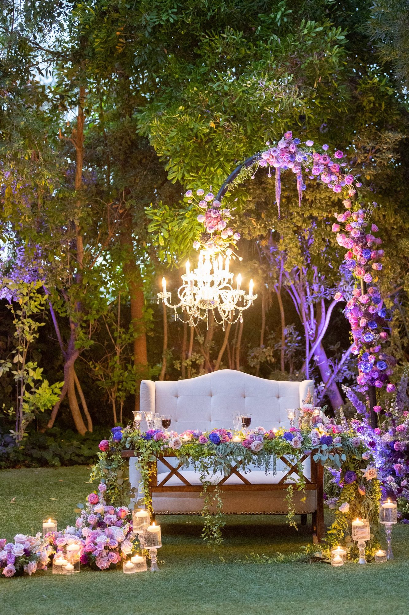 Garden sweetheart lounge under a lavender-lit chandelier