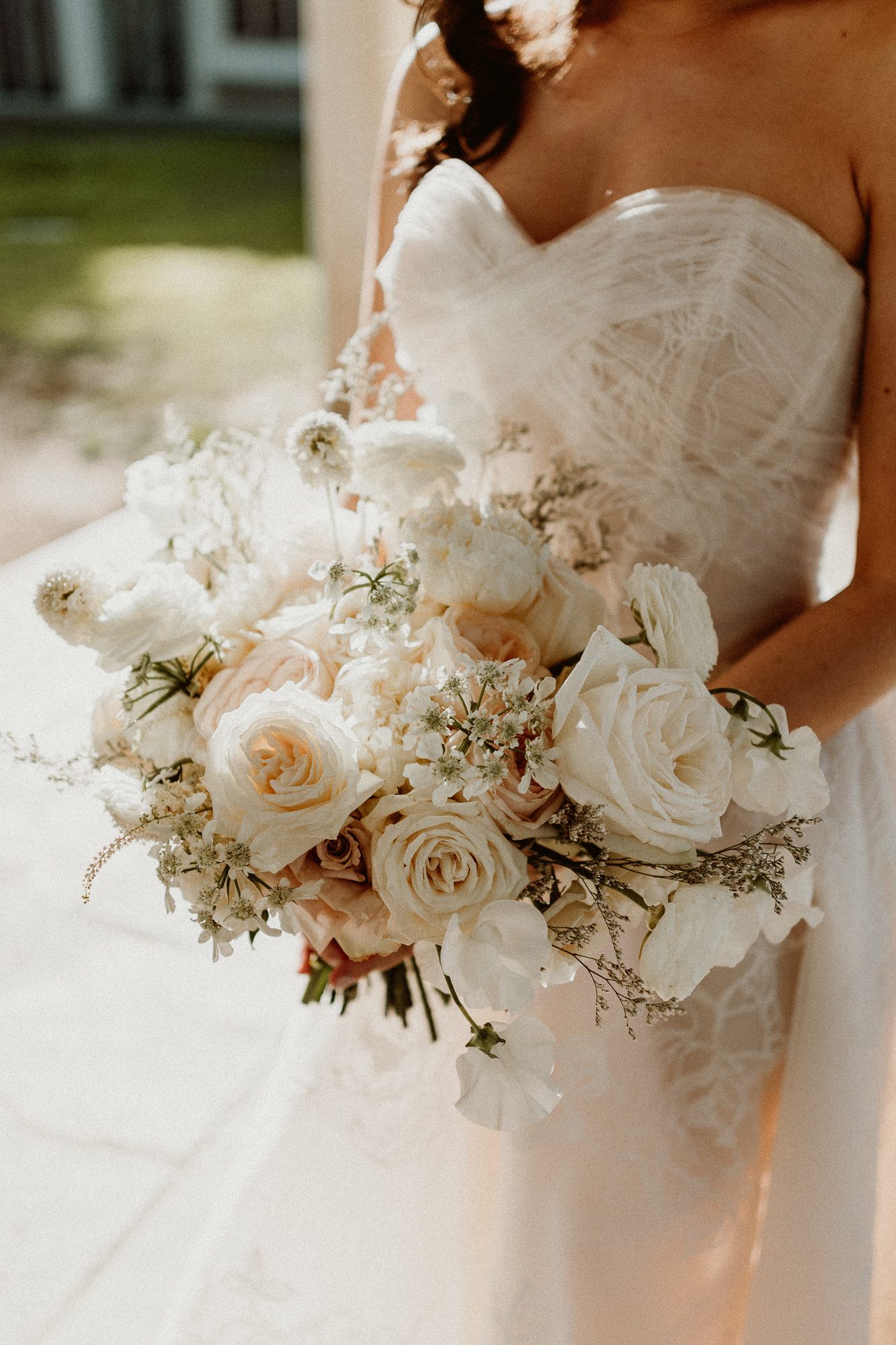 Bride holding a full white garden-rose bouquet