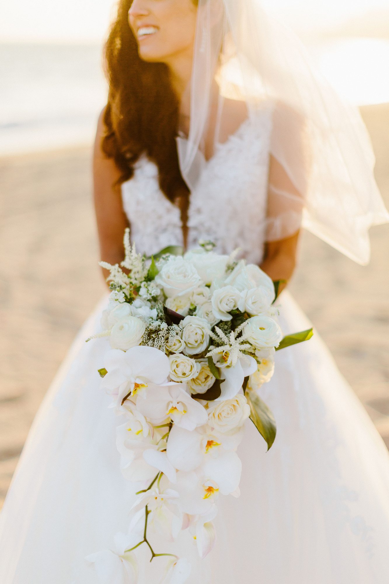 Cascading white orchid bridal bouquet on the beach