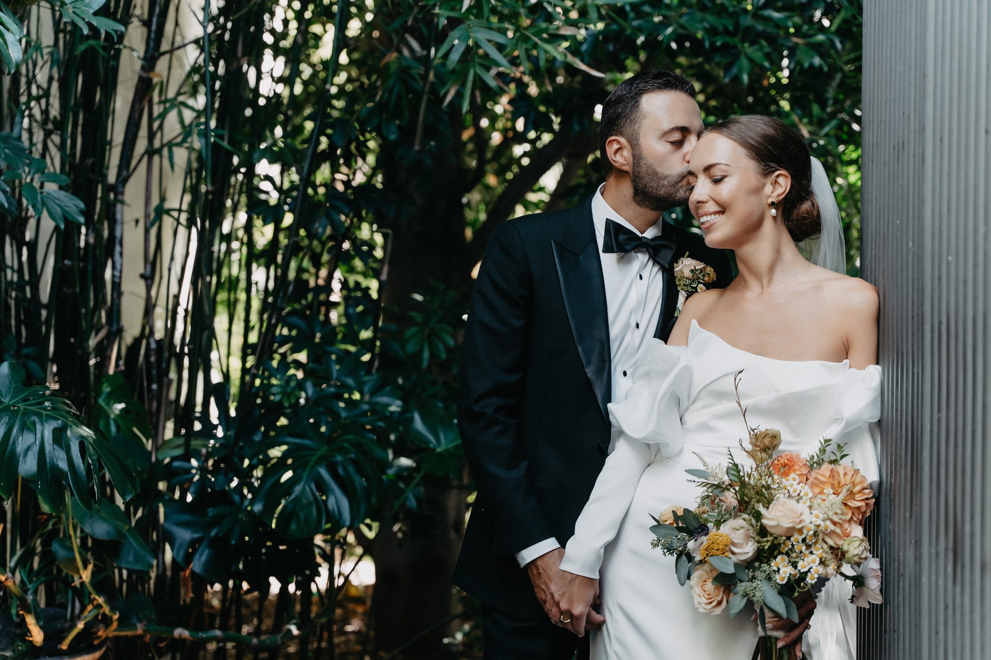 Couple with a peach and blush bridal bouquet