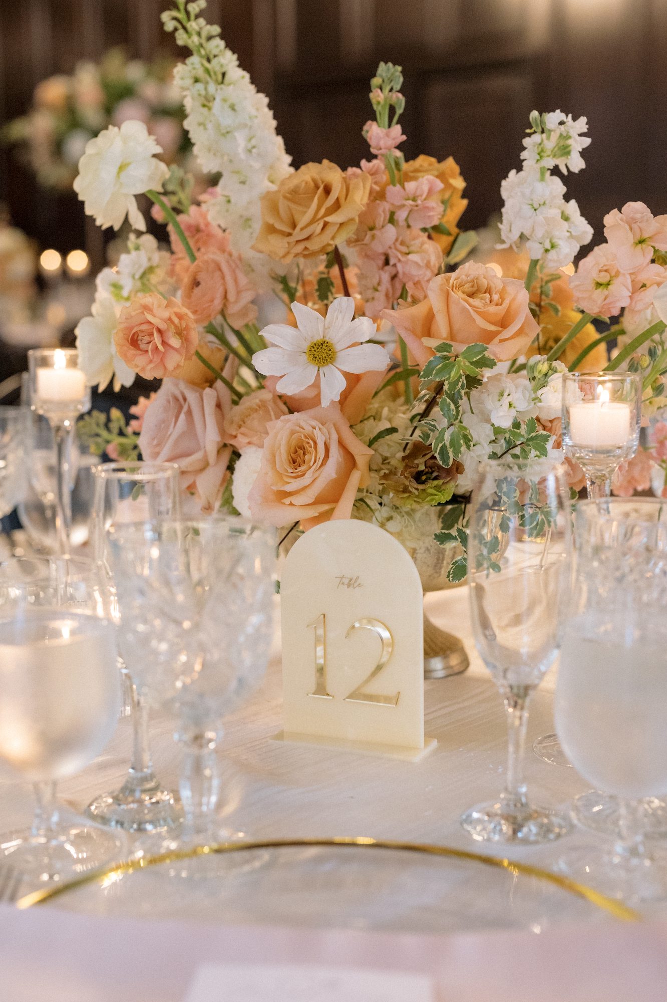 Elevated peach floral centerpiece on a candlelit table